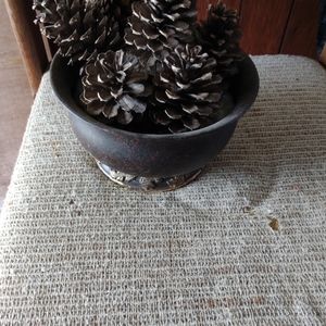 VINTAGE DECORATIVE ROUND TIN FILLED WITH NATURAL PINECONES.